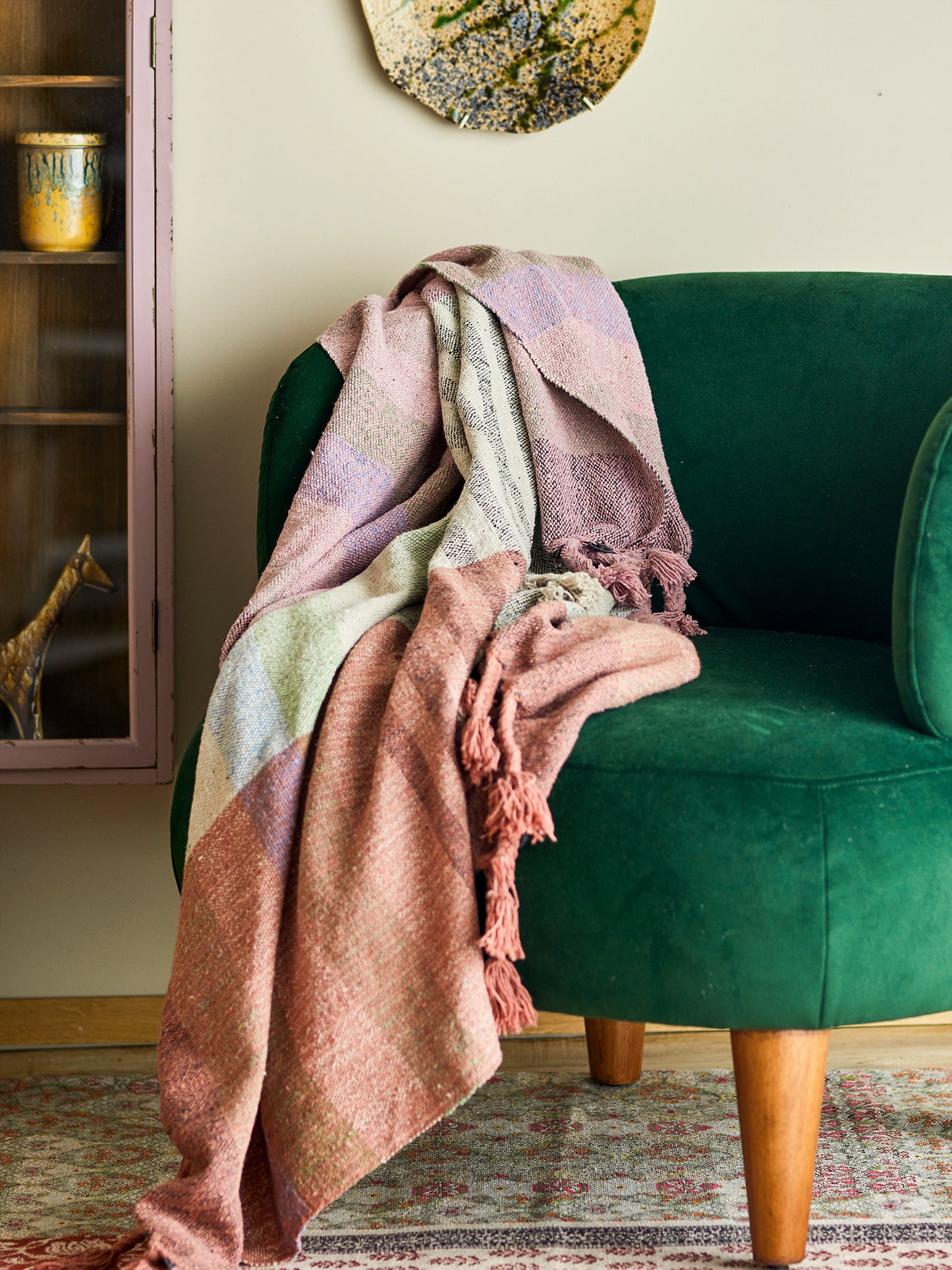 Pink striped throw draped over green chair