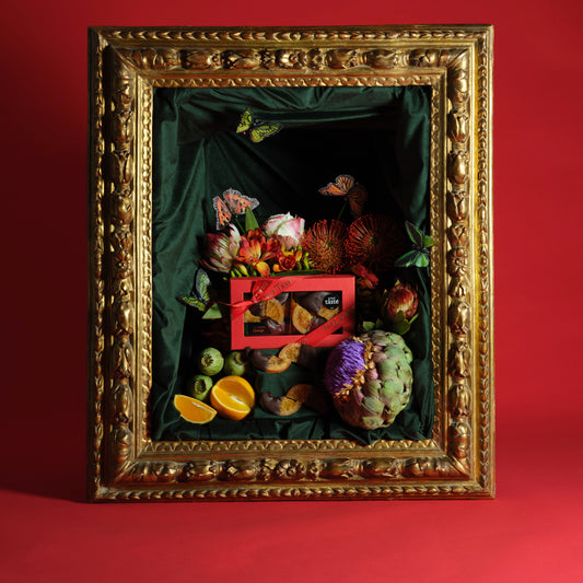 Decorative still life arrangement with fruits and flowers in a gold frame on a red background