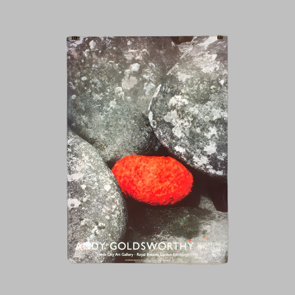 Poster featuring a sculpture by Andy Goldsworthy, with a red artwork piece surrounded by gray rocks.