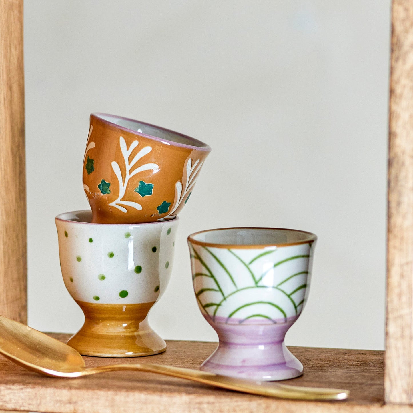 Trio of egg cups with gold spoon