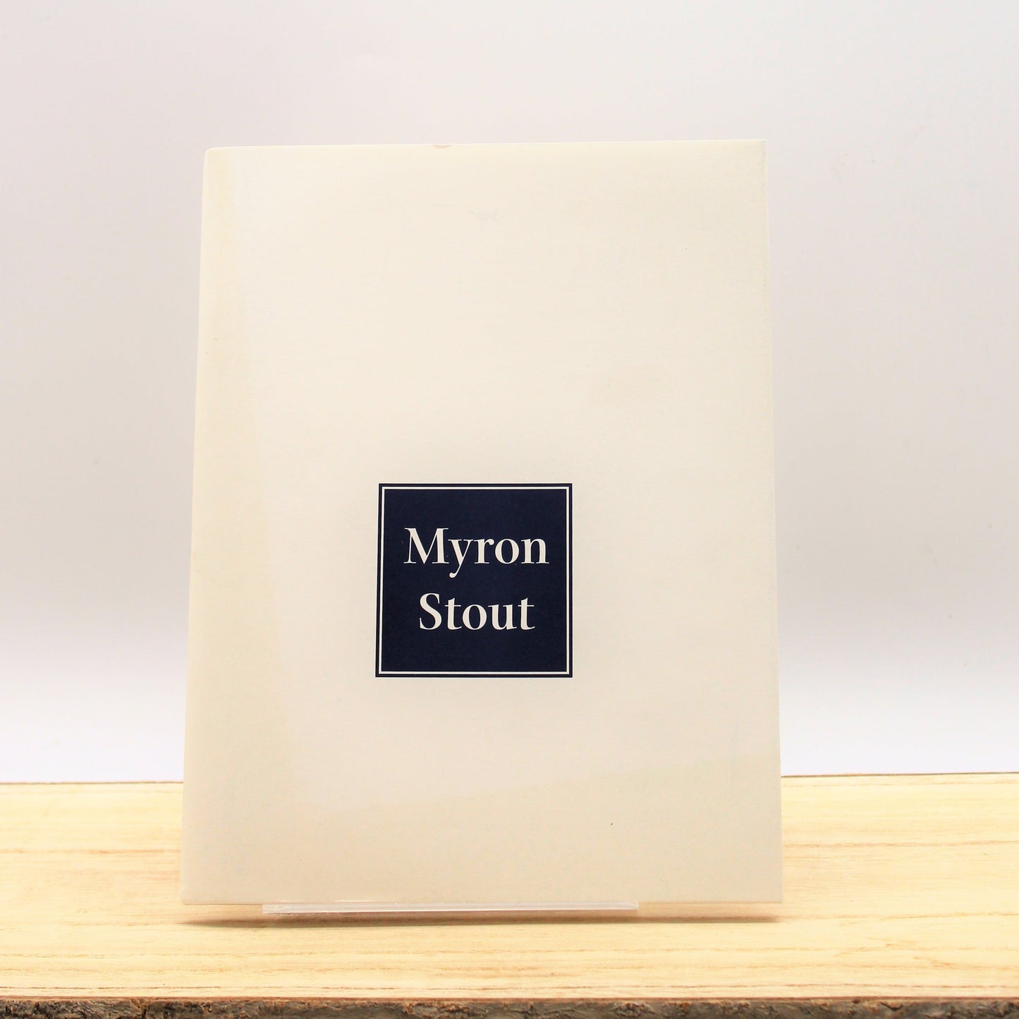 Cover of the book 'Myron Stout' with a simple design featuring the artist's name and a geometric shape in the center.